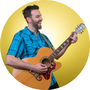 A man in a blue shirt plays a guitar