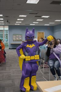 A cosplayer in a purple Batman suit