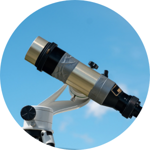 A large grey telescope against a blue sky with a cloud