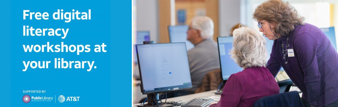 Free digital literacy workshops at your library. A woman in a purple shirt stands behind another woman sitting at a computer, showing her something on the screen