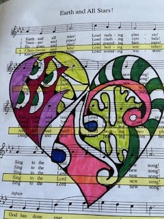 A page of sheet music with a heart drawn over it and filled in with multiple patterns and colors