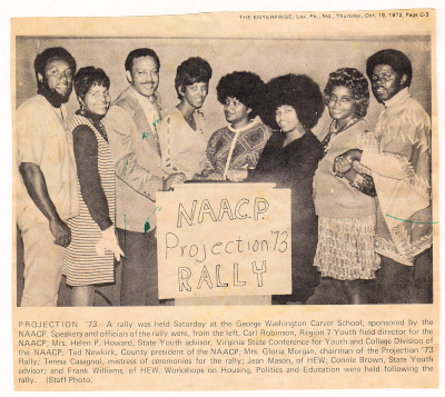 A yellowed newspaper clipping with a photo of 8 Black men and women holding a sign reading NAACP Projection '73 Rally 